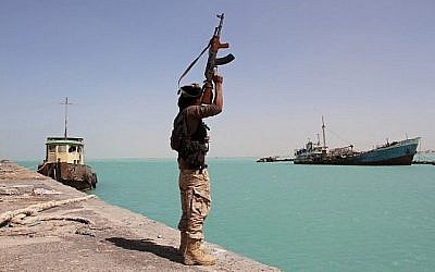 Un membre des forces progouvernementales lève son arme dans le port de Mokha, à l'ouest du Yémen, alors que les troupes soutenues par l'Arabie saoudite avancent pour chasser les rebelles Houthis chiites de la région de la mer Rouge, le 8 févrer 2017. (Crédit : AFP/Saleh al-Obeidi)