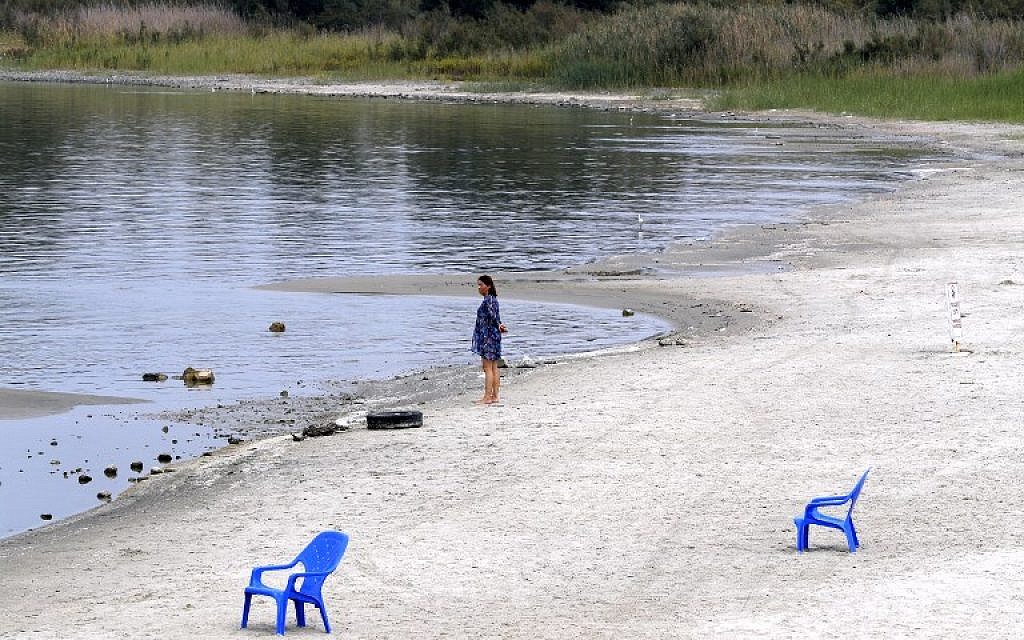 Une femme se tient sur la plage de sable du lac de Tibériade., le 8 ocotbre 2018 Les étendues de sable  sont apparues à cause d'une baisse de niveau de l'eau, attribuée à une surexploitation des ressources. (Crédit : JACK GUEZ / AFP)