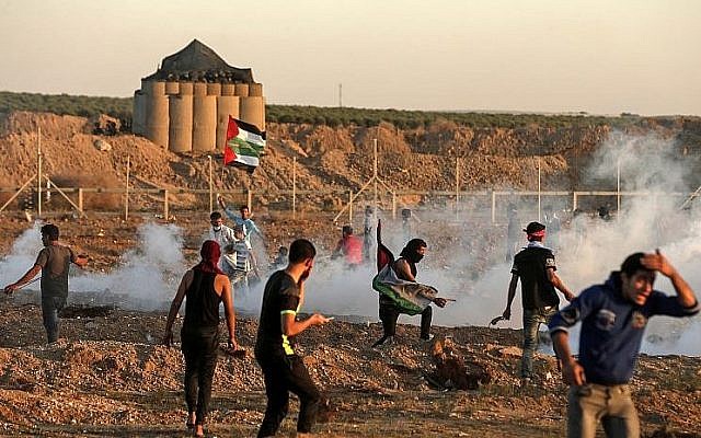 Les Palestiniens réagissent aux gaz lacrymogènes lancés par les soldats israéliens au cours d'affrontements survenus à l'est de Gaza City, près de la frontière entre Gaza et Israël, le 2 novembre 2018 (Crédit : Mahmud Hams/AFP) Les Palestiniens réagissent aux gaz lacrymogènes lancés par les soldats israéliens au cours d'affrontements survenus à l'est de Gaza City, près de la frontière entre Gaza et Israël, le 2 novembre 2018 (Crédit : Mahmud Hams/AFP)