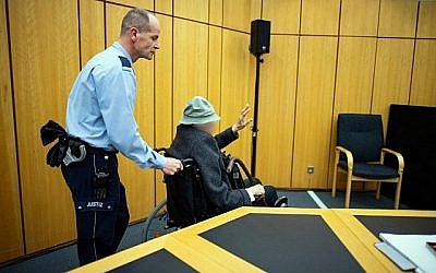 Un policier pousse un ex-garde de camp nazi de 94 ans dans un tribunal de Munster, en Allemagne, le 6 novembre 2018. (Crédit ! Guido Kirchner/dpa/AFP)