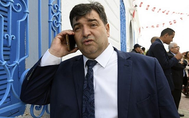 Sur cette photo prise le 2 mai 2018, on voit René Trabelsi au téléphone devant la synagogue de la Ghriba de l'île de villégiature tunisienne de Djerba. Trabelsi, qui appartient à la communauté juive de Tunisie, a été nommé ministre du Tourisme lors du dernier remaniement gouvernemental, le 5 novembre 2018. (Crédit : FETHI BELAID / AFP) Sur cette photo prise le 2 mai 2018, on voit René Trabelsi au téléphone devant la synagogue de la Ghriba de l'île de villégiature tunisienne de Djerba. Trabelsi, qui appartient à la communauté juive de Tunisie, a été nommé ministre du Tourisme lors du dernier remaniement gouvernemental, le 5 novembre 2018. (Crédit : FETHI BELAID / AFP)