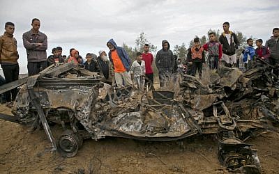 Des Palestiniens autour des décombres d'une voiture qui aurait été détruite par une frappe israélienne à Khan Younès, dans le sud de la bande de Gaza, le 12 novembre 2018. (Crédit : SAID KHATIB / AFP) Des Palestiniens autour des décombres d'une voiture qui aurait été détruite par une frappe israélienne à Khan Younès, dans le sud de la bande de Gaza, le 12 novembre 2018. (Crédit : SAID KHATIB / AFP)