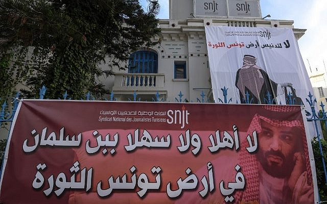 Une affiche géante placardée sur le local du Syndicat national des journalistes tunisien (SNJT), montrant un Saoudien de dos, une tronçonneuse à la main et la phrase "Non à la profanation de la Tunisie, pays de la révolution", pour protester contre la venue du prince héritier saoudien dans le contexte de l'affaire Khashoggi, à Tunis, le 26 novembre 2018. (Crédit : FETHI BELAID / AFP)