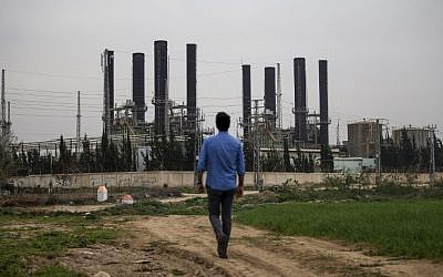 Une Palestinien devant l'unique centrale électrique de Gaza, le 15 février 2018. (Crédit : AFP PHOTO / MOHAMMED ABED) Une Palestinien devant l'unique centrale électrique de Gaza, le 15 février 2018. (Crédit : AFP PHOTO / MOHAMMED ABED)