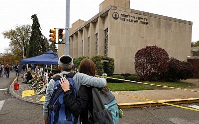 La population rend hommage aux 11 personnes tuées le 27 octobre 2018, devant un mémorial de fortune à l'extérieur de la synagogue Tree of Life, dans le quartier Squirrel Hill de Pittsburgh, le jeudi 1er novembre 2018. (Crédit : AP Photo/Gene J. Puskar)