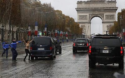 La police française arrête une militante dénudée qui se précipite vers le convoi du Donald Trump, à Paris, le 11 novembre 2018. (Crédit : AP/Jacquelyn Martin)