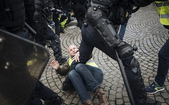 Les "gilets jaunes" aux prises avec la police anti-émeutes sur l'avenue des Champs-Elysées à Paris, le 24 novembre 2018 (Crédit : AP Photo/Kamil Zihnioglu)