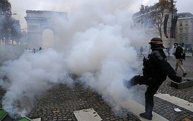 Un policier anti-émeutes sur l'avenue des Champs Elysées, près de l'Arc de Triomphe, lors d'une mobilisation des "Gilets Jaunes" contre la hausse du coût de la vie à Paris, le 24 novembre 2018 (Crédit : AP Photo/Michel Euler)