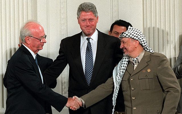 Le président Clinton invite le Premier ministre israélien Yitzhak Rabin, (gauche) et le chef de l'OLP Yasser Arafat à se serrer la main dans la Chambre Est de la Maison Blanche, le jeudi 28 septembre 1995. Le président égyptien Hosni Mubarak est derrière Arafat. (AP Photo/Doug Mills)