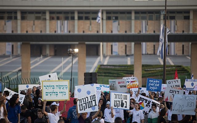 Des jeunes Israéliens tiennent des pancartes alors qu'ils protestent devant la Knesset pour réclamer une solution aux cerfs-volants incendiaires et aux roquettes lancées depuis la bande de Gaza sur les villes israéliennes, après avoir marché du sud du pays jusqu'à Jérusalem le 8 novembre 2018. (Crédit : Yonatan Sindel / Flash90)