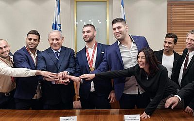 Le Premier ministre Benjamen Netanyahu et la ministre de la Culture et des Sports Miri Regev, entourés par les membres de l'équipe nationale de Judo, au cabinet du Premier ministre à Jérusalem, le 8 novembre 2018.  (Crédit photo : GPO)