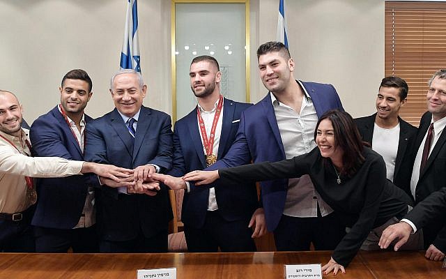 Le Premier ministre Benjamen Netanyahu et la ministre de la Culture et des Sports Miri Regev, entourés par les membres de l'équipe nationale de Judo, au cabinet du Premier ministre à Jérusalem, le 8 novembre 2018.  (Crédit photo : GPO)