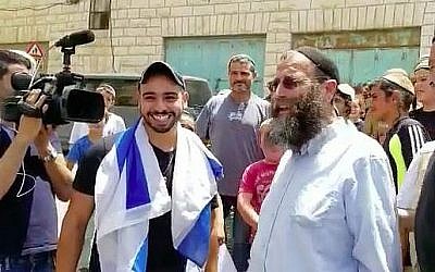 Elor Azaria (G), qui a été condamné et emprisonné pour le meurtre d'un terroriste palestinien blessé dans la ville de Hébron, en Cisjordanie, en mars 2016, a le sourire en se rendant en homme libre, le 3 juillet 2018, à Hébron. A côté de lui se trouve l'activiste d'extrême droite Baruch Marzel. (Capture d'écran/Haverim Laset Tzara organisation)