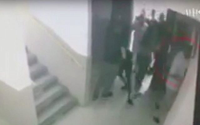 Des inspecteurs de police interpellent un lycéen israélien d'origine éthiopienne à Ashdod, sous le regard du directeur de l'école. (Crédit : Kan)