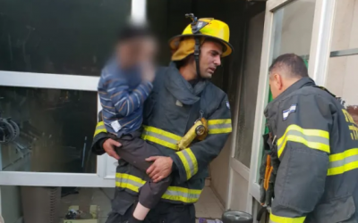 Un pompier évacue une enfant d'un incendie à Beit Shemesh le 15 novembre 2018. (Crédit : sapeur-pompiers israéliens)