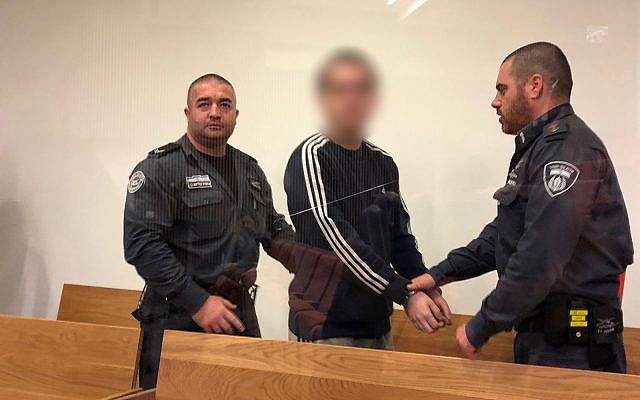 M., un Israélo-américain reconnu coupable d'avoir fait de fausses alertes à la bombe contre des centres communautaires juifs et d'autres cibles à travers le monde, arrive devant le tribunal de district de Tel Aviv le 22 novembre 2018 pour sa sentence. (Jacob Magid/Times of Israel)
