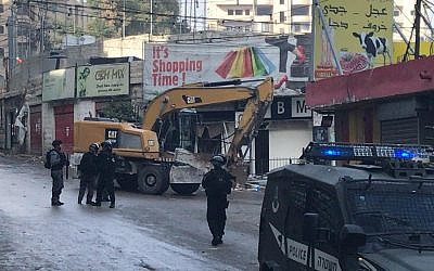 La police accompagne les bulldozers qui démoliront les vitrines de magasins du camp de réfugiés de Shuafat à Jérusalem-Est, le 21 novembre 2018 (Autorisation :  Ir Amim)