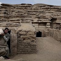 Un employé porte une statue retrouvée dans une tombe des pyramides de Saqqara, le 10 novembre 2018. (Crédit : Nariman El-Mofty/AP) Un employé porte une statue retrouvée dans une tombe des pyramides de Saqqara, le 10 novembre 2018. (Crédit : Nariman El-Mofty/AP)