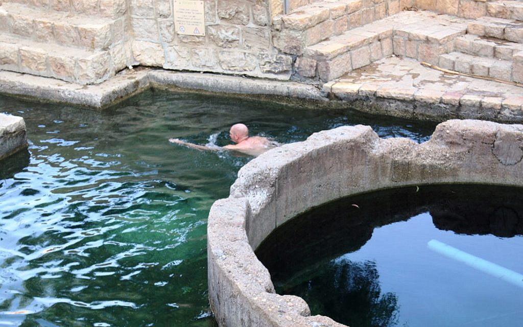Un visiteur se baigne dans le bassin d'Ein Fawwar, dans les collines de Judée (Crédit : Shmuel Bar-Am)