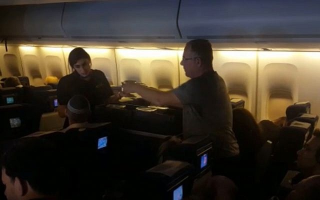 Une hôtesse sert un passager sur un vol El Al en provenance de New York et en direction d'Israël le 18 novembre 2018 (Capture d'écran : Israel Hayom)