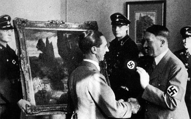 Adolf Hitler, (à droite), regarde une œuvre d'art volée, en 1940. (Crédit : Photo12/UIG via Getty Images) Adolf Hitler, (à droite), regarde une œuvre d'art volée, en 1940. (Crédit : Photo12/UIG via Getty Images)