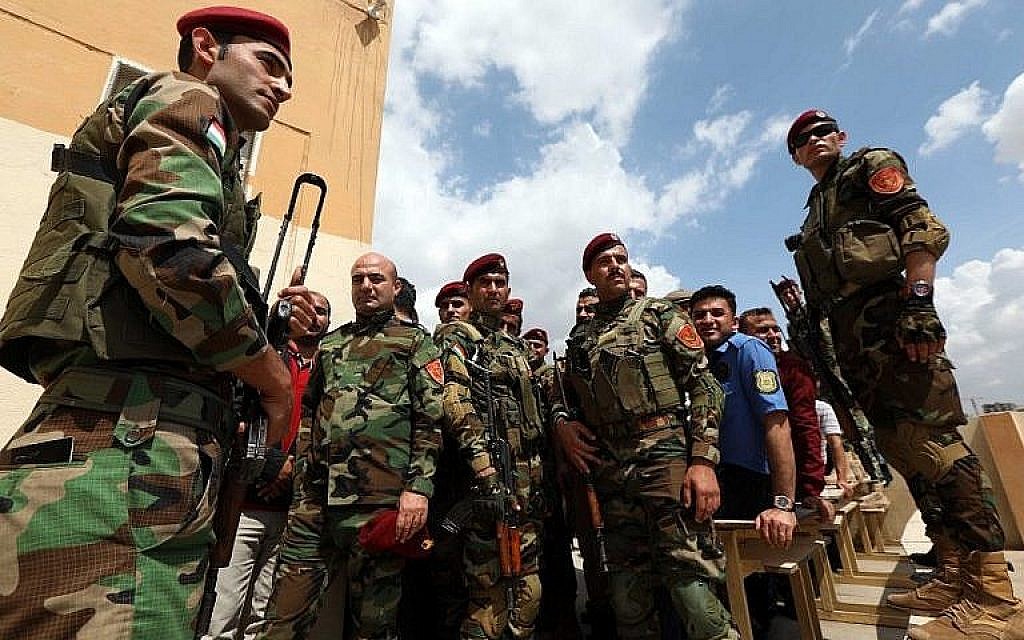 Des membres kurdes irakiens de la sécurité font la queue devant un bureau de vote pour les élections législatives du 10 mai 2018 à Arbil, capitale de la région autonome kurde du nord de l'Irak. (AFP Photo/Safin Hamed)