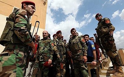 Des membres kurdes irakiens de la sécurité font la queue devant un bureau de vote pour les élections législatives du 10 mai 2018 à Arbil, capitale de la région autonome kurde du nord de l'Irak. (AFP Photo/Safin Hamed)