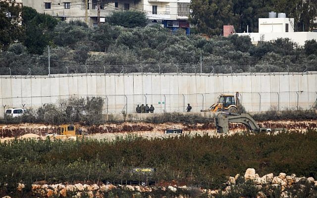 Des soldats israéliens devant une machine d'excavation près de Metula, à la frontière avec le Liban, le 4 décembre 2018. (Crédit : JALAA MAREY / AFP) Des soldats israéliens devant une machine d'excavation près de Metula, à la frontière avec le Liban, le 4 décembre 2018. (Crédit : JALAA MAREY / AFP)