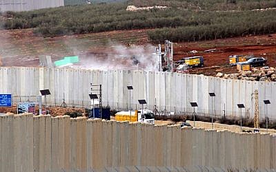 Cette photo prise le 4 décembre 2018 depuis le village de Kfar Kila, au sud du Liban, montre une vue des machines israéliennes opérant derrière le mur frontalier en Israël (D). (Crédit : Ali DIA / AFP)