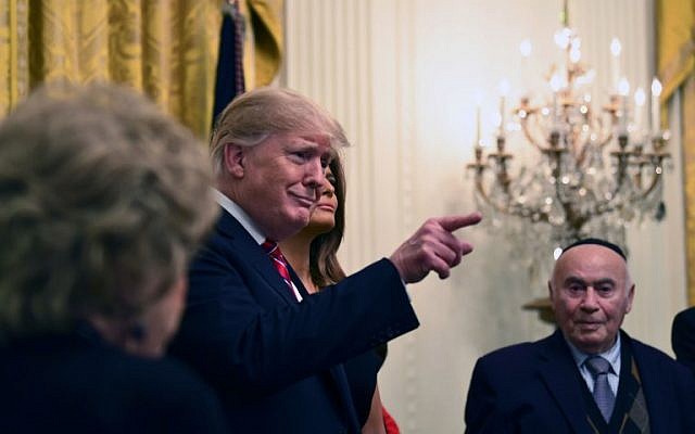 Le président américain Donald Trump et la First lady Melania Trump lors d'une fête de Hanoukka avec des survivants de la Shoah à la Maison Blanche à Washington, le 6 décembre 2018 (Crédit : Brendan Smialowski / AFP) Le président américain Donald Trump et la First lady Melania Trump lors d'une fête de Hanoukka avec des survivants de la Shoah à la Maison Blanche à Washington, le 6 décembre 2018 (Crédit : Brendan Smialowski / AFP)