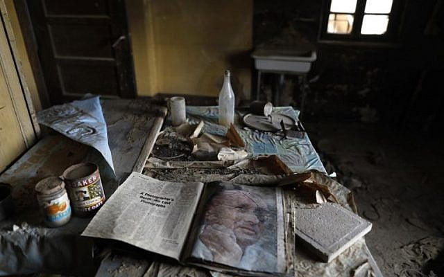 Une copie d'un magazine avec le portrait du général israélien Moshe Dayan, sur la table d'une église étiopienne de Qasr al-Yahud, fermée depuis 50 ans. (Crédit : MENAHEM KAHANA / AFP)