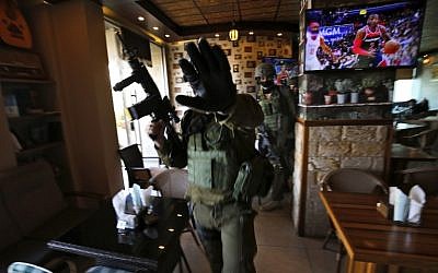 Des soldats israéliens dans un restaurant pendant un raid à Ramallah, le 10 décembre 2018, après un attentat terroriste en Cisjordanie. (Crédit : ABBAS MOMANI / AFP)