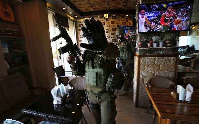 Des soldats israéliens dans un restaurant pendant un raid à Ramallah, le 10 décembre 2018, après un attentat terroriste en Cisjordanie. (Crédit : ABBAS MOMANI / AFP)