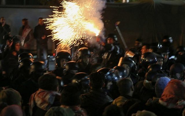 La police anti-émeutes lance des gaz lacrymogènes lors d'une manifestation contre la décision du gouvernement d'élever les impôts dans la capitale d'Amman, en Cisjordanie, le 13 décembre 2018 (Crédit :  Khalil MAZRAAWI / AFP)