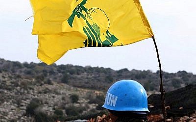 Photo prise le 16 décembre dans le village de Meiss al-Jabal on December 16, 2018.La FINUL observe les opérations d'excavation par l'armée israélienne du côté israélien de la frontière. A droite, un drapeau du Hezbollah.(Crédit : AP/Mahmoud Zayyat/AFP)