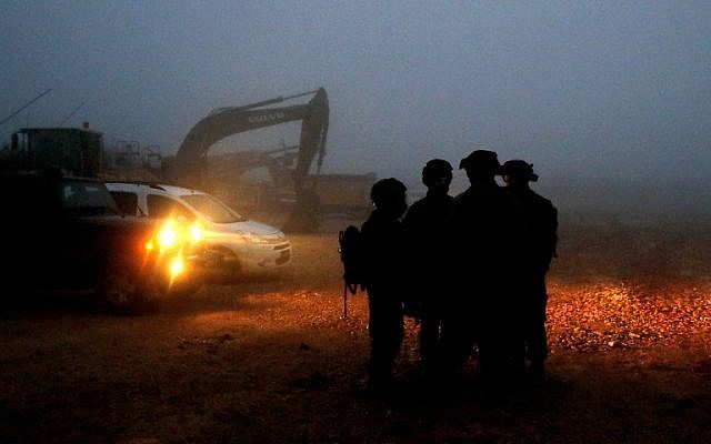 Des soldats israéliens se dirigent vers des engins de chantier utilisés pour localiser les tunnels d'attaque du Hezbollah le long de la frontière avec le Liban, près de la ville de Metula, au nord d'Israël, le 19 décembre 2018. (Jack Guez/AFP)
