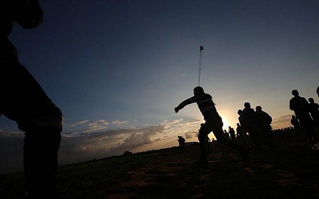 Un Palestinien utilise une fronde pour jeter des pierres pendant des émeutes près de la frontière avec Israël, à Khan Younès, dans le sud de la bande de Gaza, le 21 décembre 2018 (Crédit : Said Khatib/AFP) Un Palestinien utilise une fronde pour jeter des pierres pendant des émeutes près de la frontière avec Israël, à Khan Younès, dans le sud de la bande de Gaza, le 21 décembre 2018 (Crédit : Said Khatib/AFP)