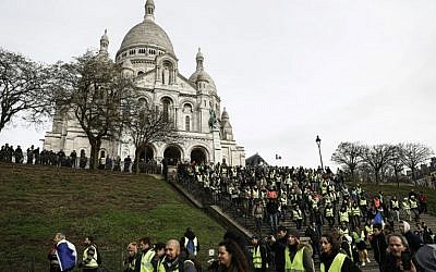 Certains manifestants des gilets jaunes réunis sur la colline de Montmartre, à Paris, devant la basilique du Sacré-Coeur, le 22 décembre 2018 (Crédit :  Sameer Al-Doumy / AFP)