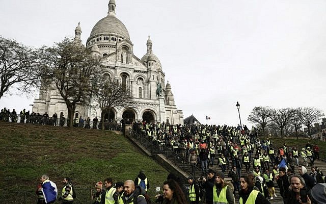 Certains manifestants des gilets jaunes réunis sur la colline de Montmartre, à Paris, devant la basilique du Sacré-Coeur, le 22 décembre 2018 (Crédit : Sameer Al-Doumy / AFP) Certains manifestants des gilets jaunes réunis sur la colline de Montmartre, à Paris, devant la basilique du Sacré-Coeur, le 22 décembre 2018 (Crédit : Sameer Al-Doumy / AFP)