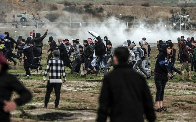 Des Palestiniens courent lors d'affrontements avec les forces israéliennes de l'autre côté de la barrière frontalière, à l'est de la ville de Gaza, le 28 décembre 2018. (Mahmud Hams/AFP) Des Palestiniens courent lors d'affrontements avec les forces israéliennes de l'autre côté de la barrière frontalière, à l'est de la ville de Gaza, le 28 décembre 2018. (Mahmud Hams/AFP)