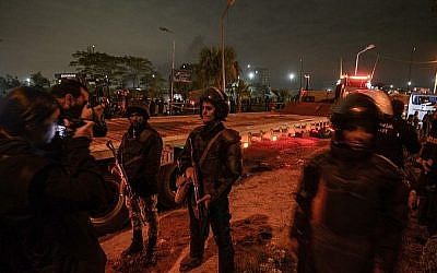 Les membres des forces égyptiennes de sécurité gardent la scène d'un attentat contre un bus touristique dans la province de Giza, au sud de la capitale du Caire, le 28 décembre 2018 (Crédit : MOHAMED EL-SHAHED / AFP) Les membres des forces égyptiennes de sécurité gardent la scène d'un attentat contre un bus touristique dans la province de Giza, au sud de la capitale du Caire, le 28 décembre 2018 (Crédit : MOHAMED EL-SHAHED / AFP)