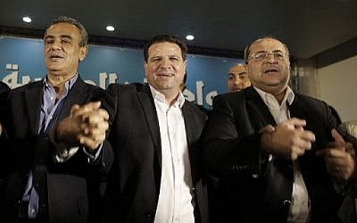 Les candidats de la Liste arabe unie, de gauche à droite : le député Jamal Zahalka, Ayman Odeh, chef de la Liste, et le député Ahmad Tibi au siège de la formation dans la ville de Nazareth, alors qu'ils réagissent aux sondages de sortie des urnes, le 17 mars 2015. (Crédit : AFP/Ahmad Gharabli)