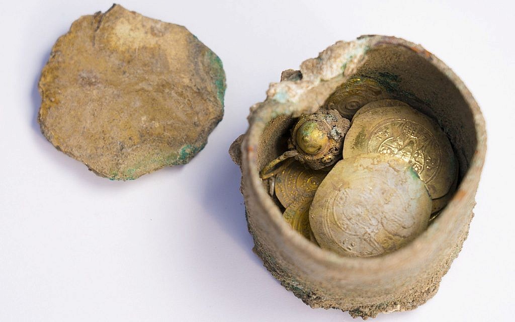 Le pot de pièces d'or et une boucle d'oreille découverts lors de fouilles archéologiques à Césarée, (Crédit : Caesarea Development Corporation)
