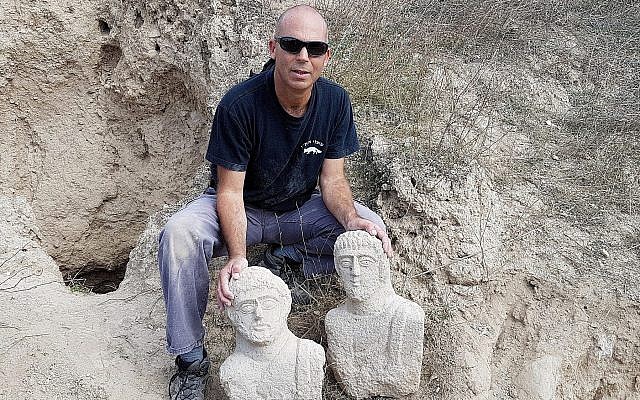 Nir Distelfeld, inspecteur de l'Unité de prévention des vols de l'Autorité israélienne des antiquités, avec les  deux bustes funéraires en calcaire qui ont été découverts après les fortes pluies du mois de décembre dans la région de Beit Shean par une randonneuse (Crédit : Eitan Klein, Autorité israélienne des antiquités)