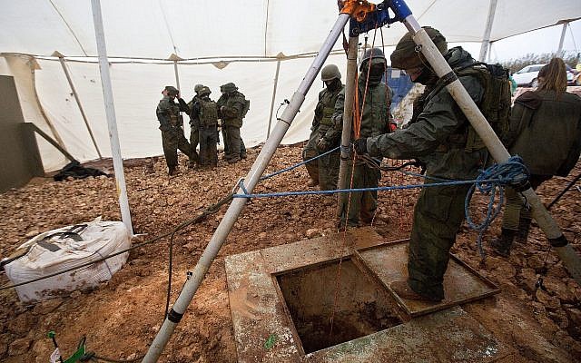 Des soldats israéliens se tiennent autour de l'ouverture qui mène à un tunnel qui, selon l'armée, a été creusé par l'organisation terroriste du Hezbollah à la frontière entre Israël et le Liban, près de Metulla, le 19 décembre 2018. (AP Photo/Sebastian Scheiner)
