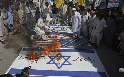 Des musulmans chiites brûlent des drapeaux israéliens et américains lors d'un rassemblement pour marquer la Journée Al-Qods (Jérusalem) à Peshawar, Pakistan, le vendredi 23 juin 2017. (AP Photo/Muhammad Sajjad)