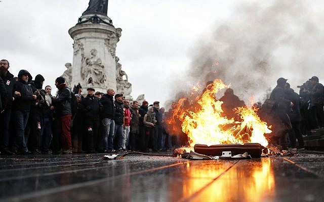 Une poubelle brûle alors que des lycéens manifestent à Paris, le vendredi 7 décembre 2018. (Crédit : AP / Thibault Camus) Une poubelle brûle alors que des lycéens manifestent à Paris, le vendredi 7 décembre 2018. (Crédit : AP / Thibault Camus)