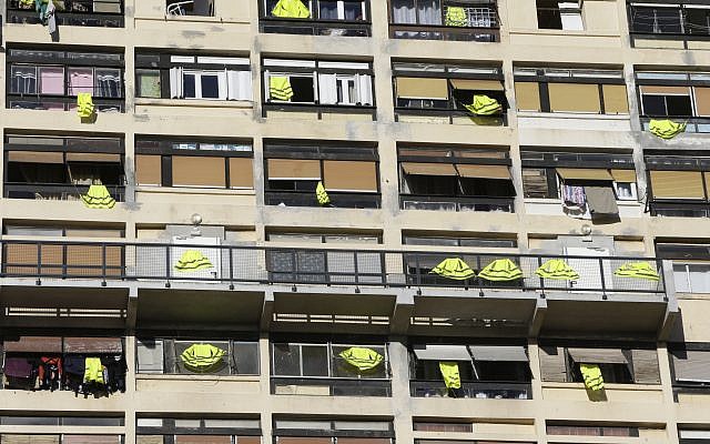 Des gilets jaunes sont suspendus sur le toit et aux fenêtres d’un immeuble, le vendredi 7 décembre 2018 à Marseille. (Crédit : AP / Claude Paris) Des gilets jaunes sont suspendus sur le toit et aux fenêtres d’un immeuble, le vendredi 7 décembre 2018 à Marseille. (Crédit : AP / Claude Paris)