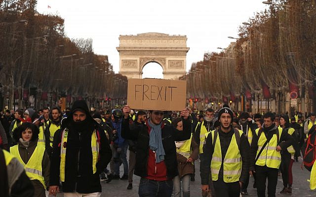 Des gilets jaunes défilent à Paris, sur les Champs Élysées, le 30 novembre 2018 (Crédit : via AP) Des gilets jaunes défilent à Paris, sur les Champs Élysées, le 30 novembre 2018 (Crédit : via AP)