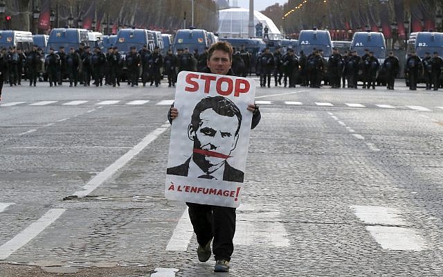 Un manifestant porte le portrait du président français Emmanuel Macron lors d'une manifestation sur la célèbre avenue des Champs-Élysées à Paris, samedi 8 décembre 2018. (Crédit : AP / Michel Euler) Un manifestant porte le portrait du président français Emmanuel Macron lors d'une manifestation sur la célèbre avenue des Champs-Élysées à Paris, samedi 8 décembre 2018. (Crédit : AP / Michel Euler)